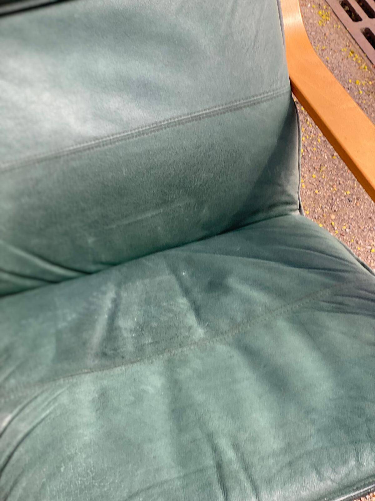 Scandinavian rocking chair with curved wood and green leather, IKEA Poäng.