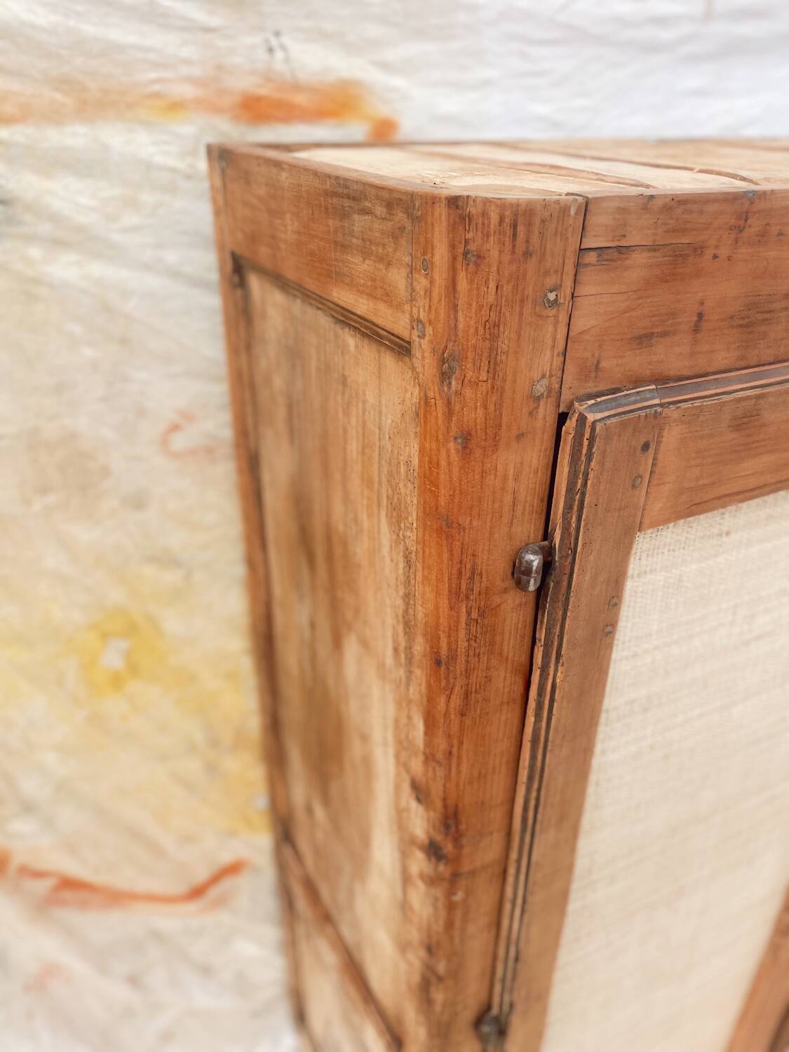 Low cabinet in raw wood and woven raffia.