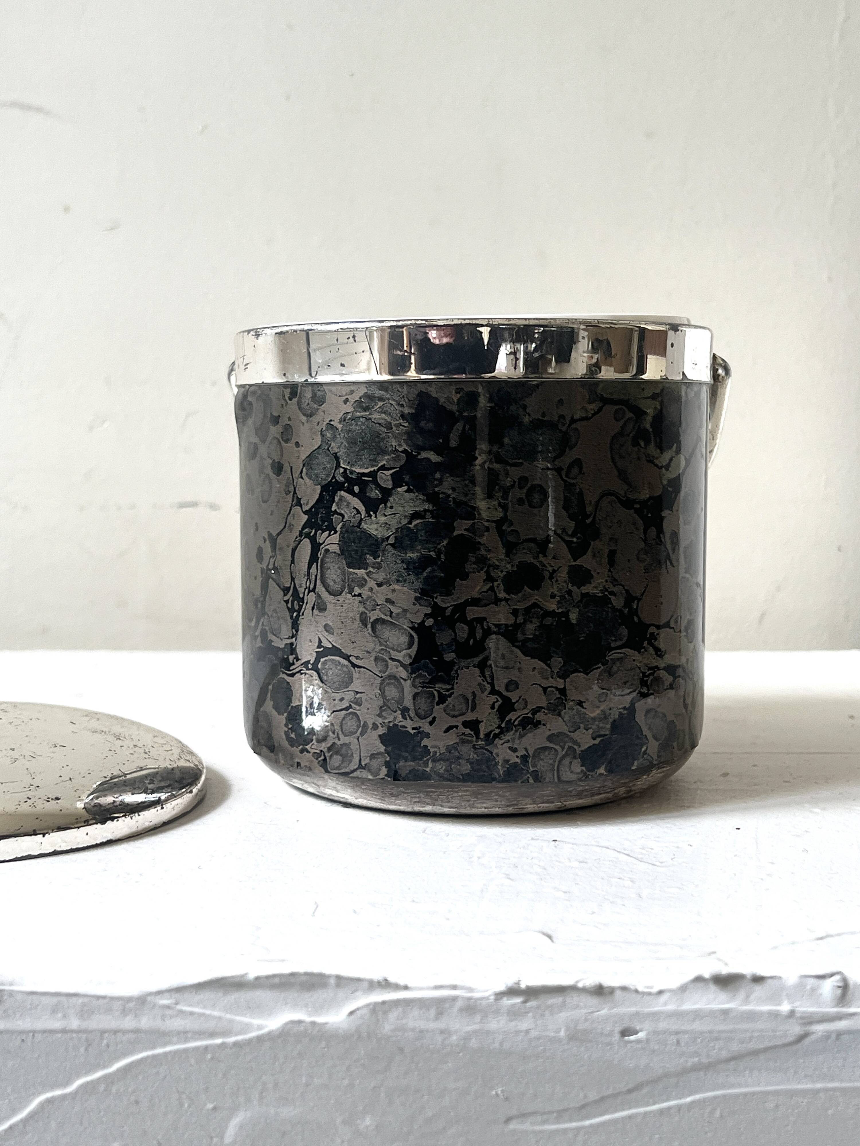 Vintage chrome metal ice bucket with black marbled design, 1970s style.