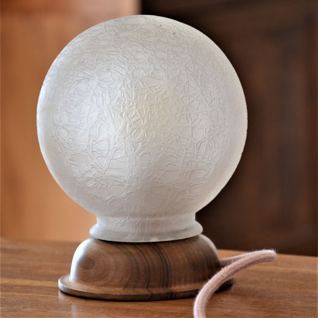 White glass globe table lamp with geometric reliefs