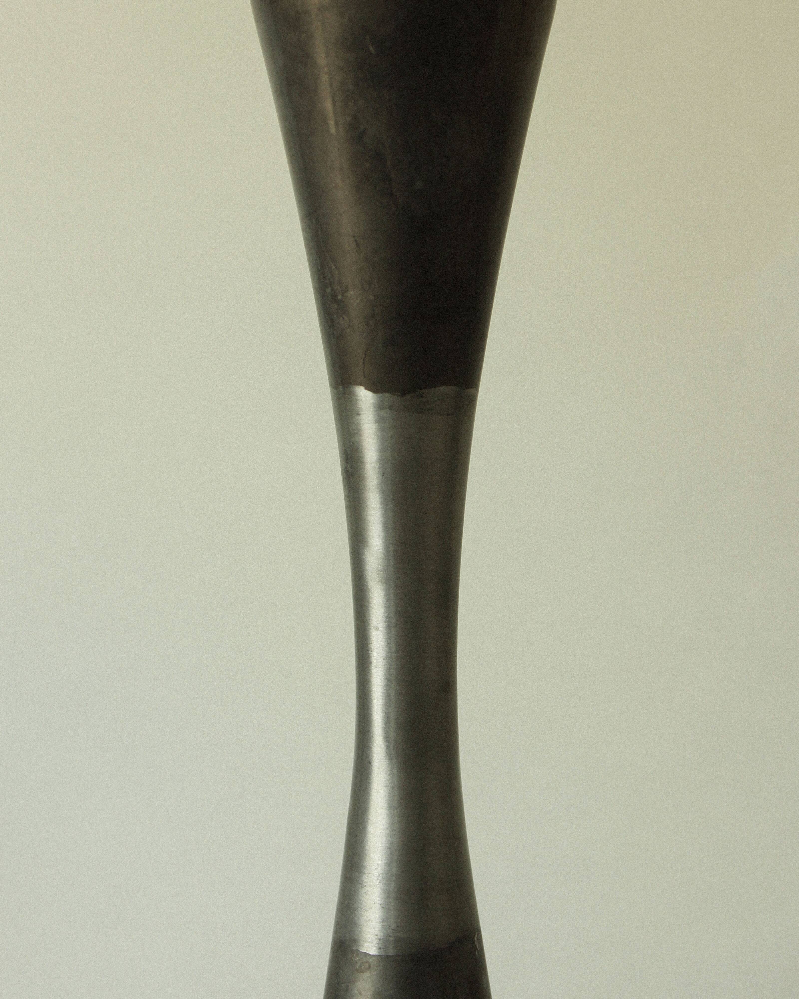 Set of three diabolo-shaped candle holders made of cast steel.