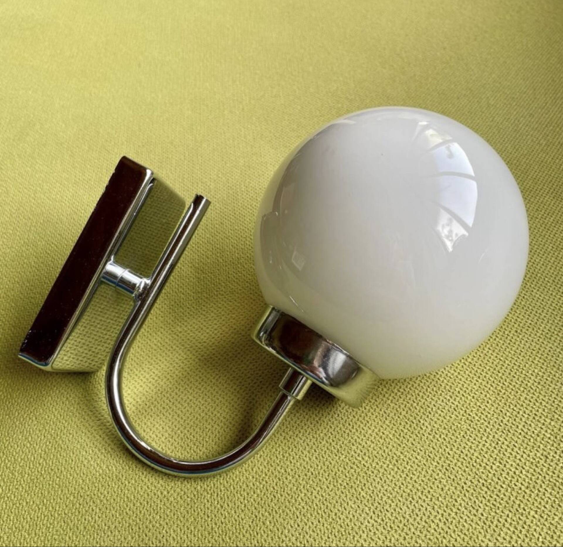 Pair of chrome metal wall lights with white glass globe.
