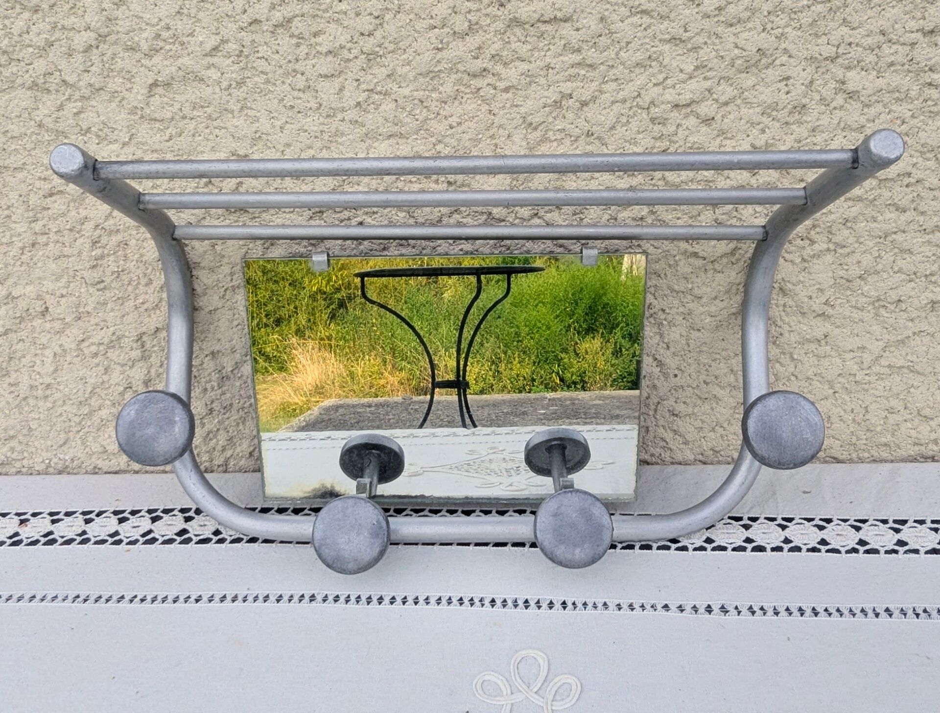 Vintage train style wall-mounted hat rack with angled mirror.