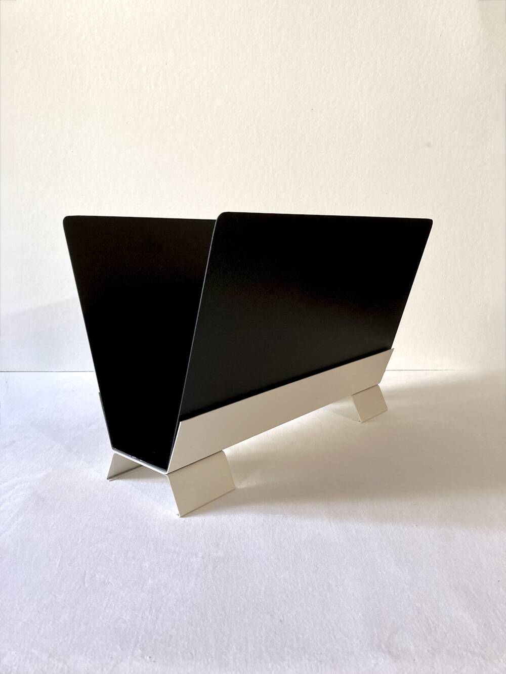 Black and cream metal magazine rack, 1950s.