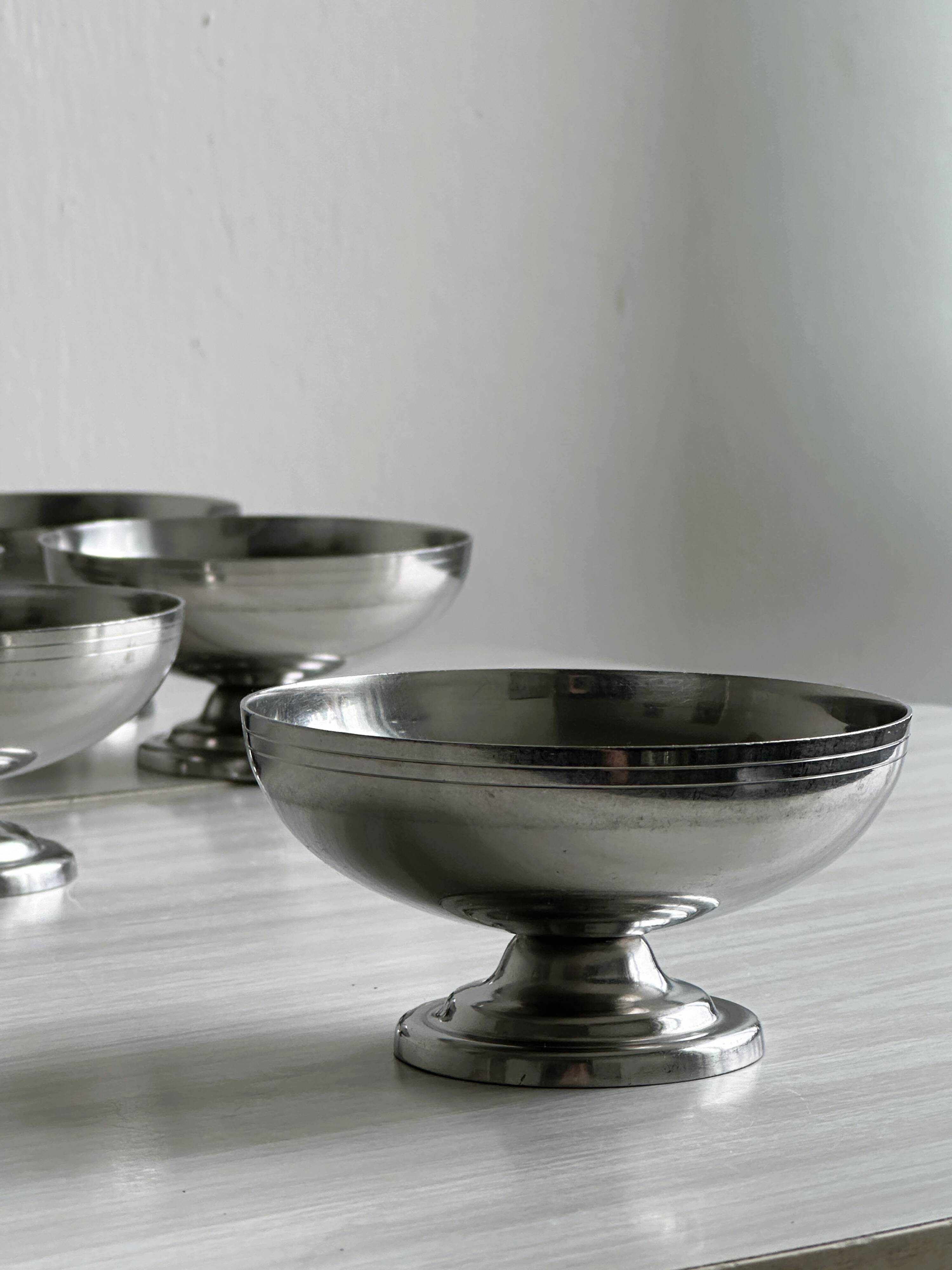 5 silver metal cups.