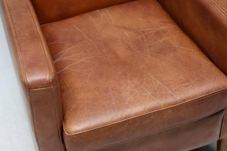 Pair of Art Deco armchairs in brown leather and teak, Netherlands, 1970s.