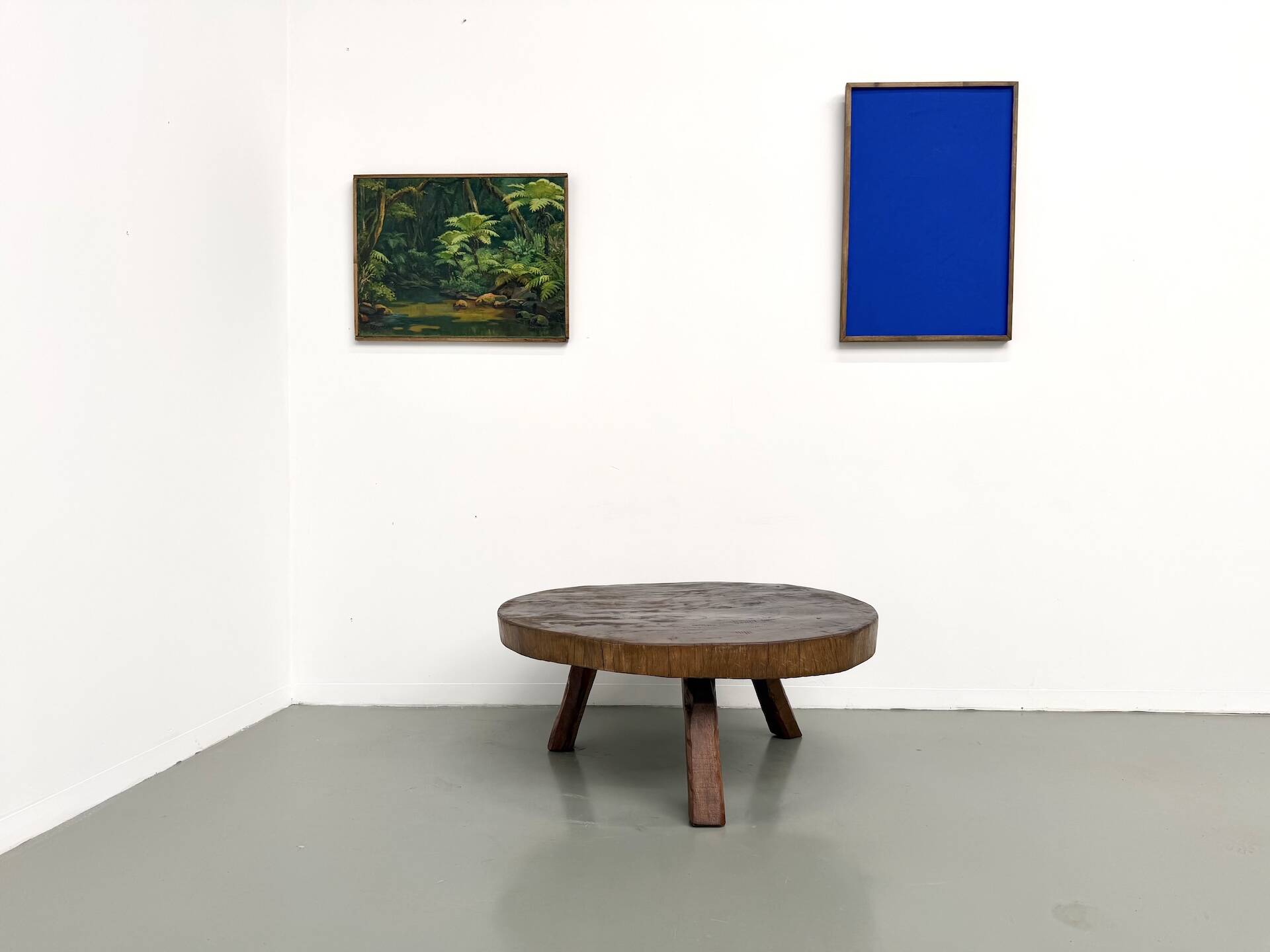 Brutalist coffee table in solid teak, monolithic slab, tripod base.