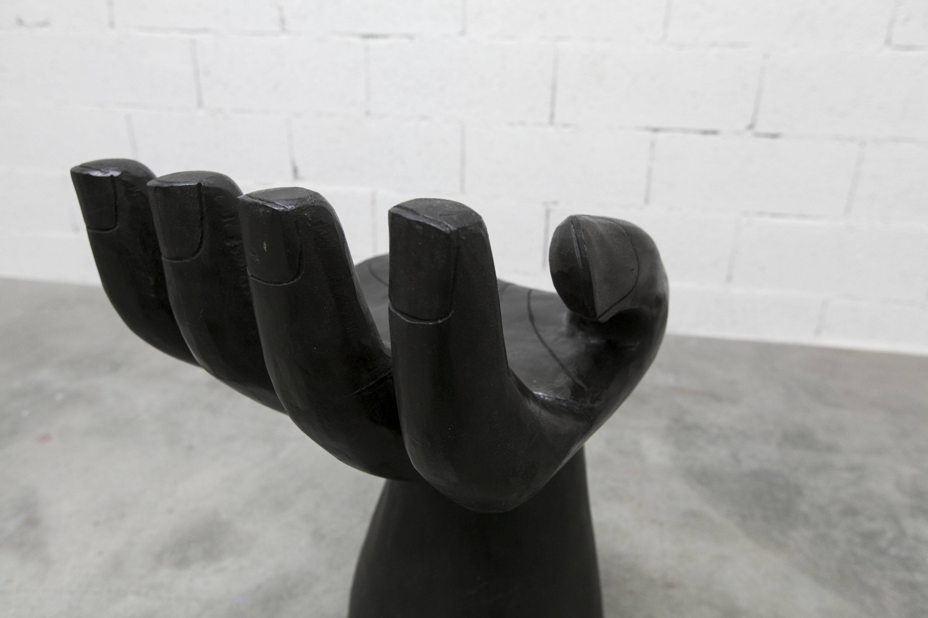 Black armchair chair in carved wood in the shape of a hand