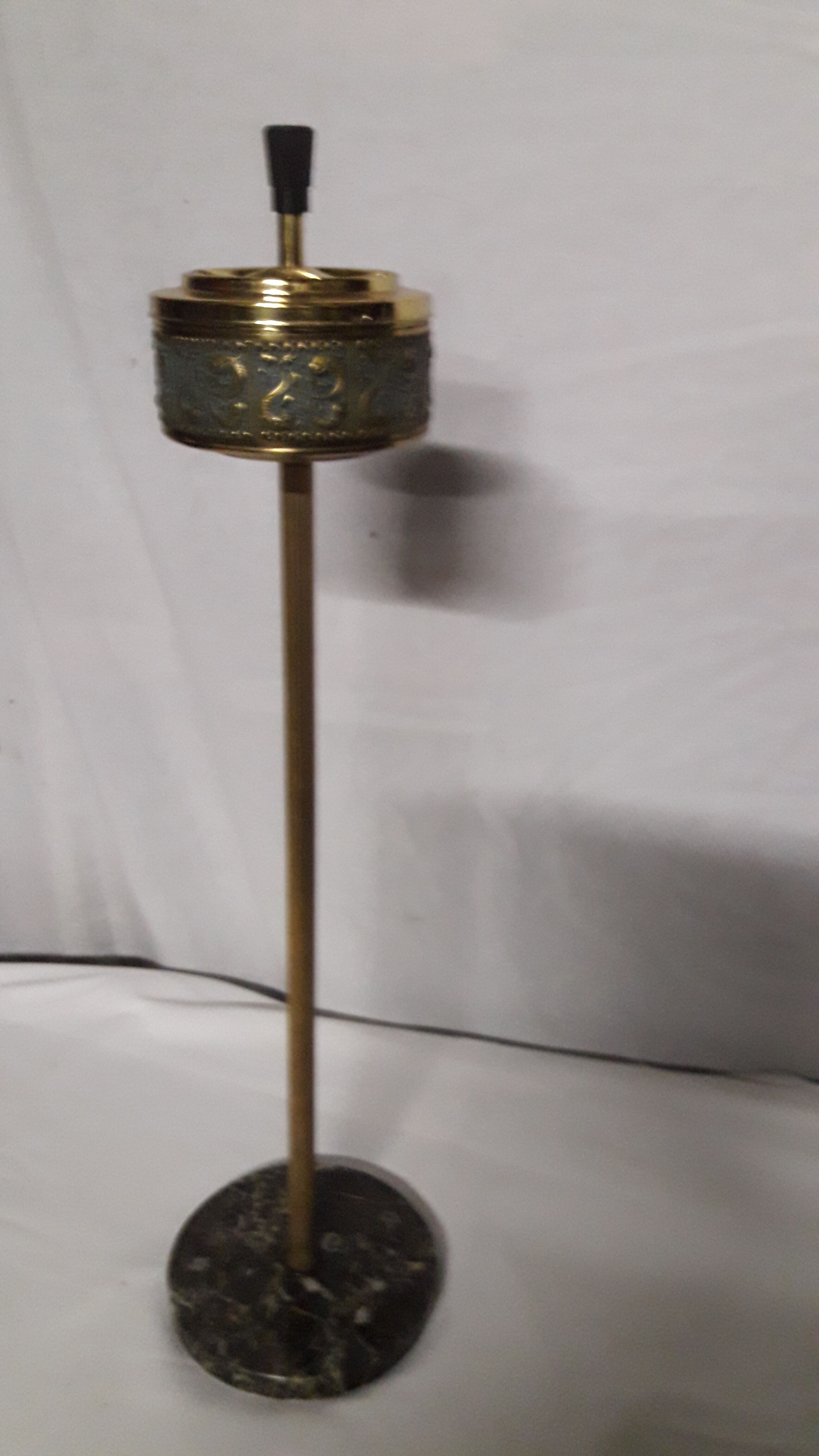 Gold metal standing ashtray and black marble base