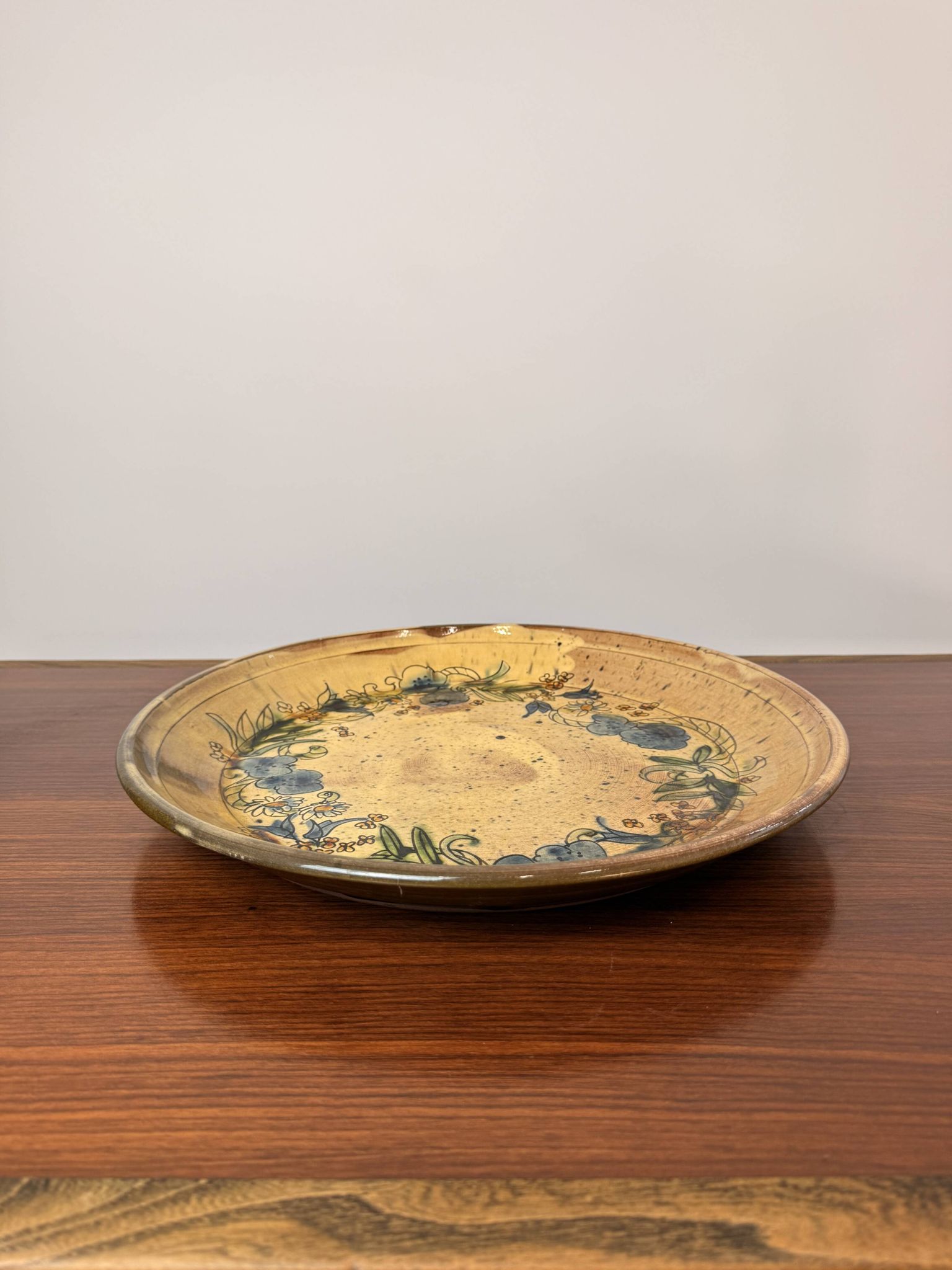 Vintage round ceramic plate with floral decoration.