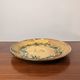 Vintage round ceramic plate with floral decoration.