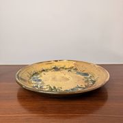 Vintage round ceramic plate with floral decoration.