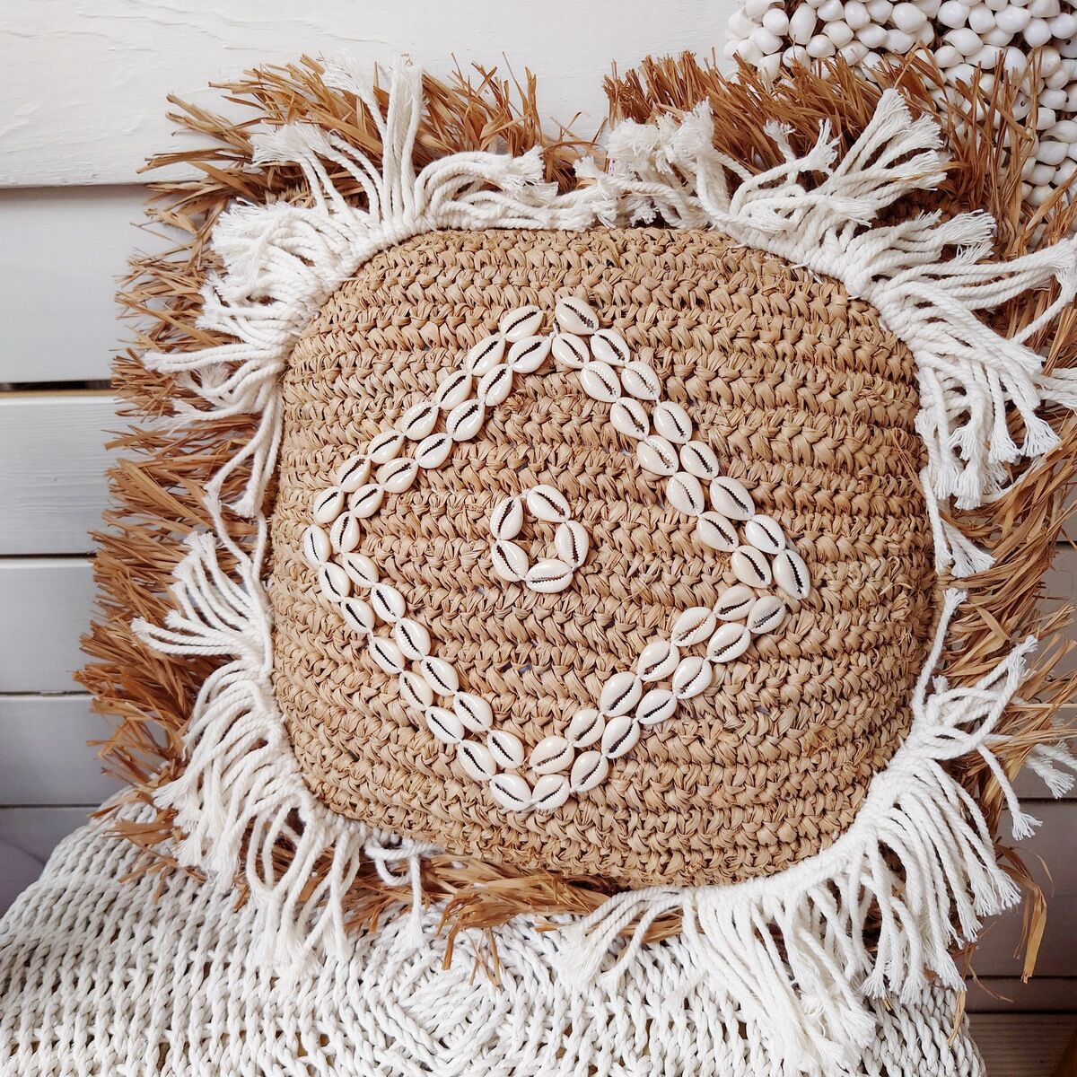 Cushion cover in natural raffia, shells and embroidery in macramé.