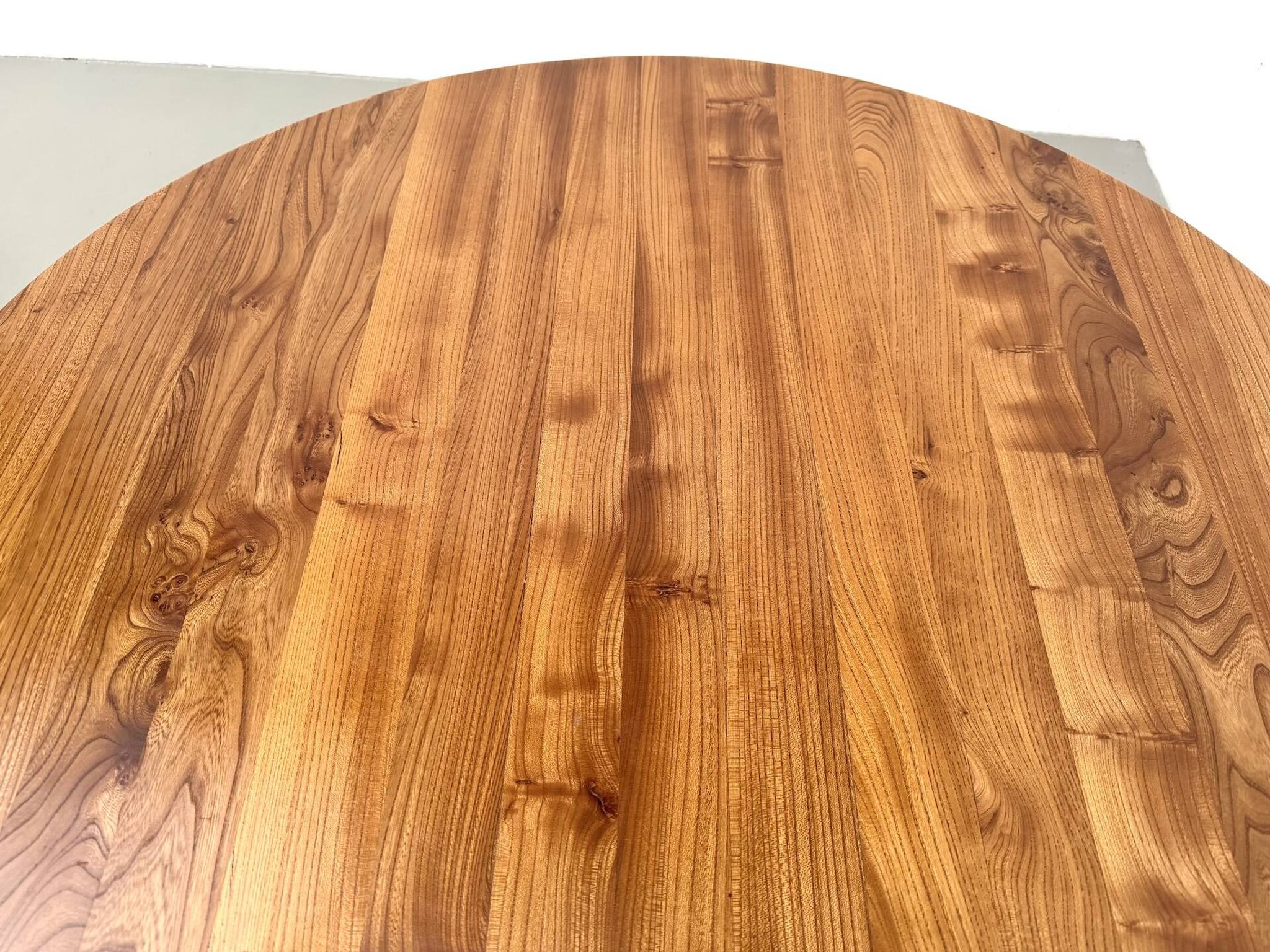 Table ronde moderniste en orme massif, piètement croisé