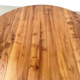 Modernist round table in solid elm, crossed legs.