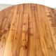 Modernist round table in solid elm, crossed legs.