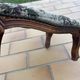 Antique wooden footstool with hand-carved details and floral upholstery –