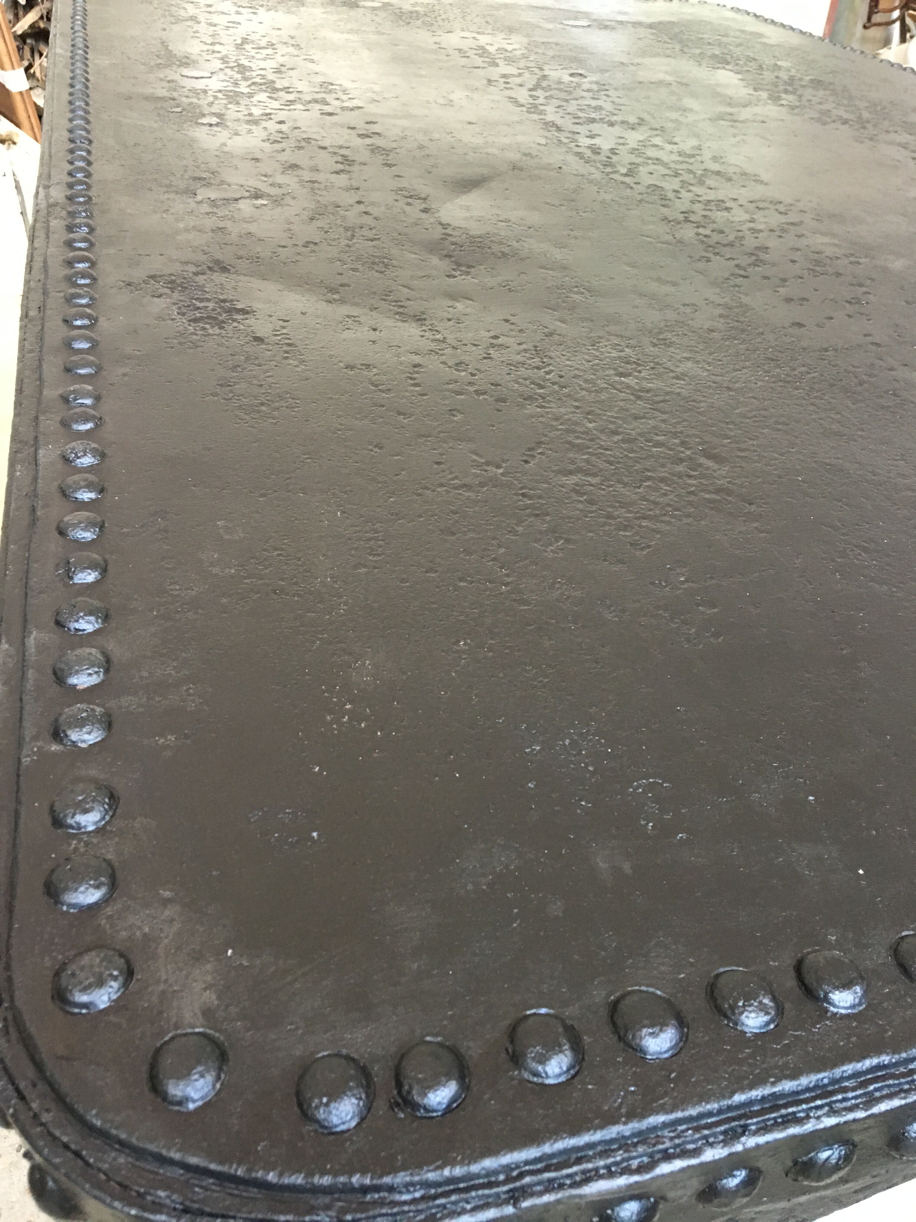 large industrial table in graphite black riveted metal