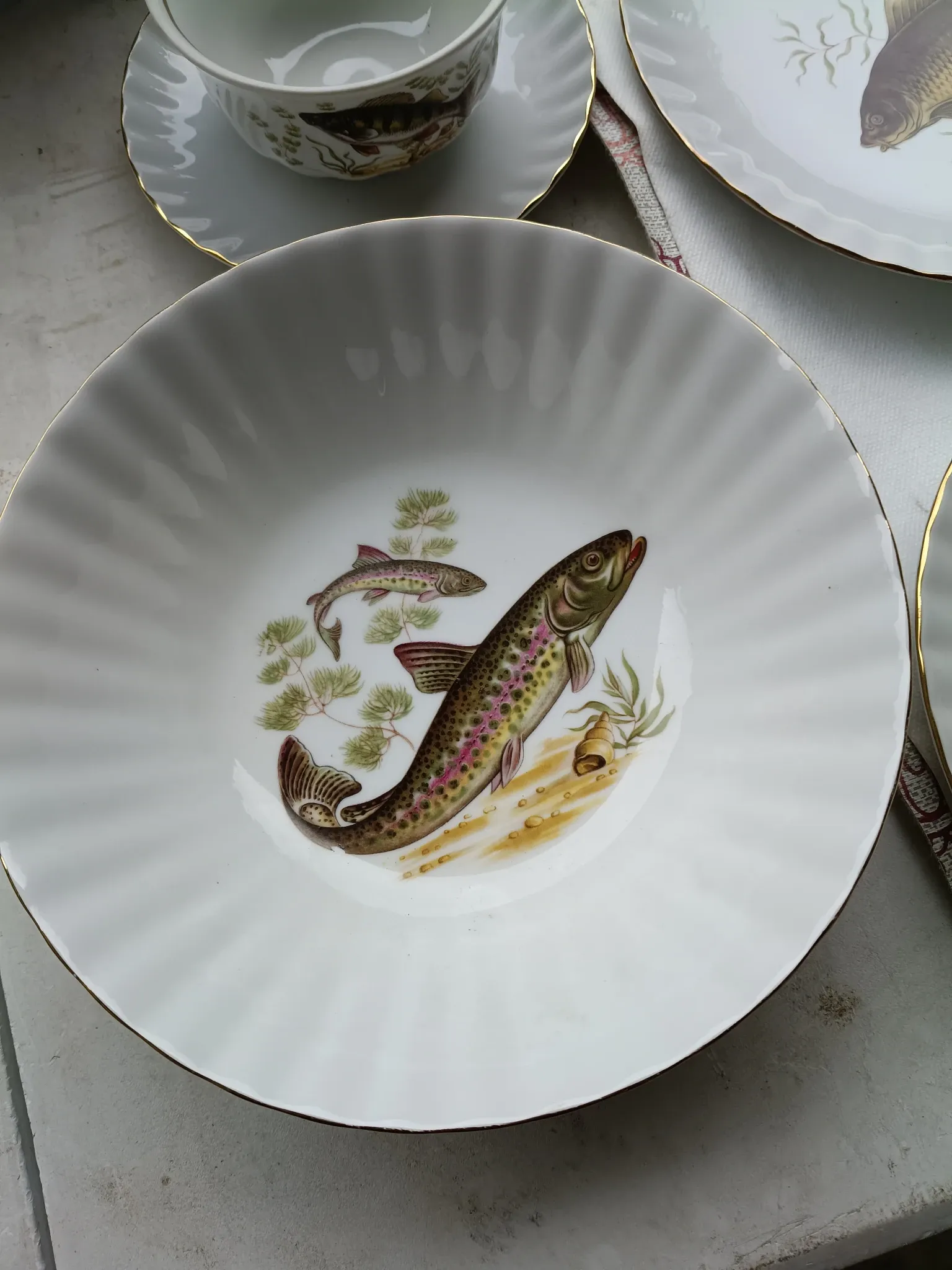 vintage porcelain dinner service with fish pattern and gold trim