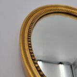 Small old oval mirror in gilded wood
