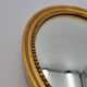 Small old oval mirror in gilded wood