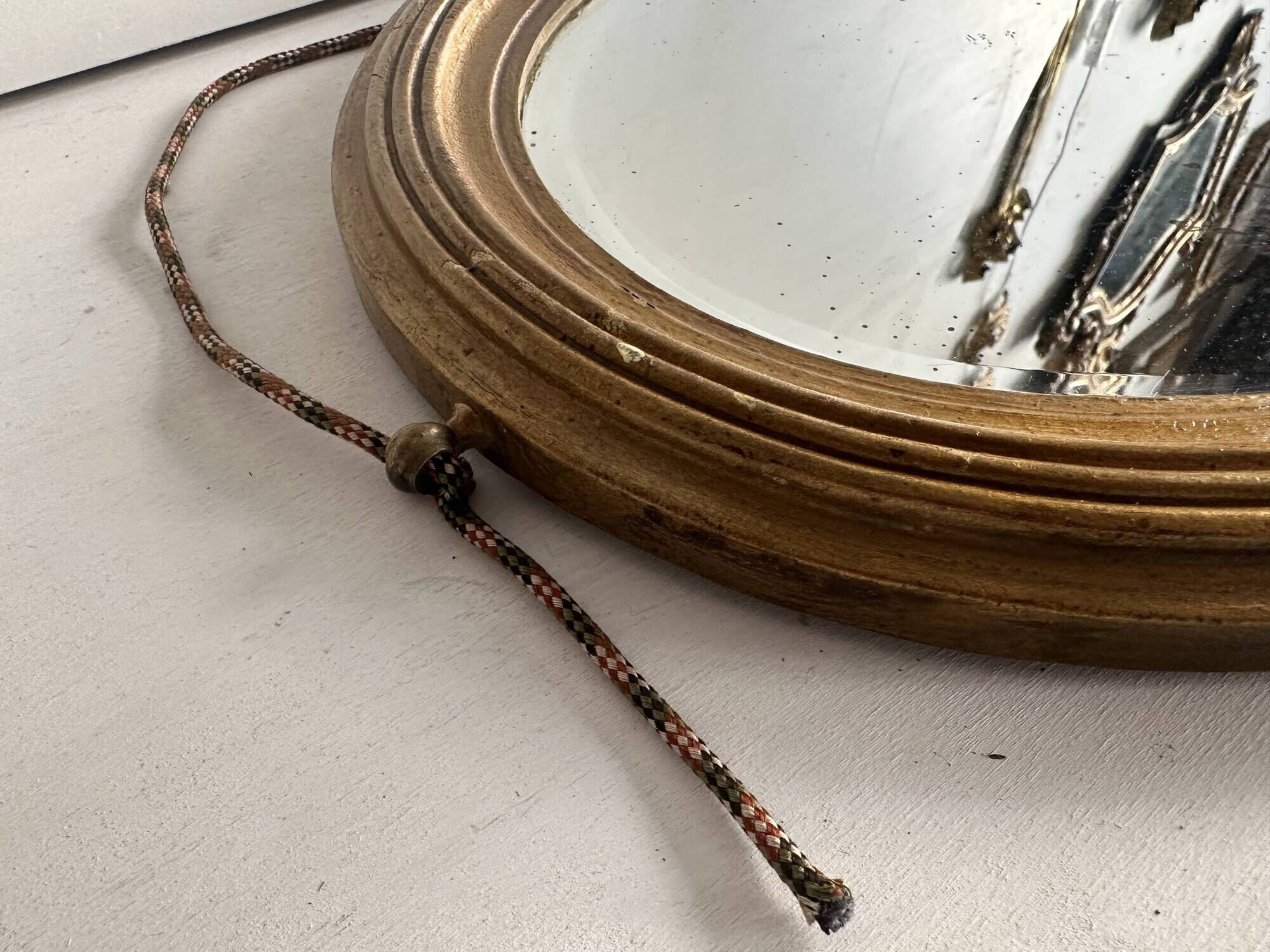 Antique oval mirror in gilded wood, bevelled mercury glass, 19th century.