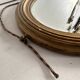 Antique oval mirror in gilded wood, bevelled mercury glass, 19th century.