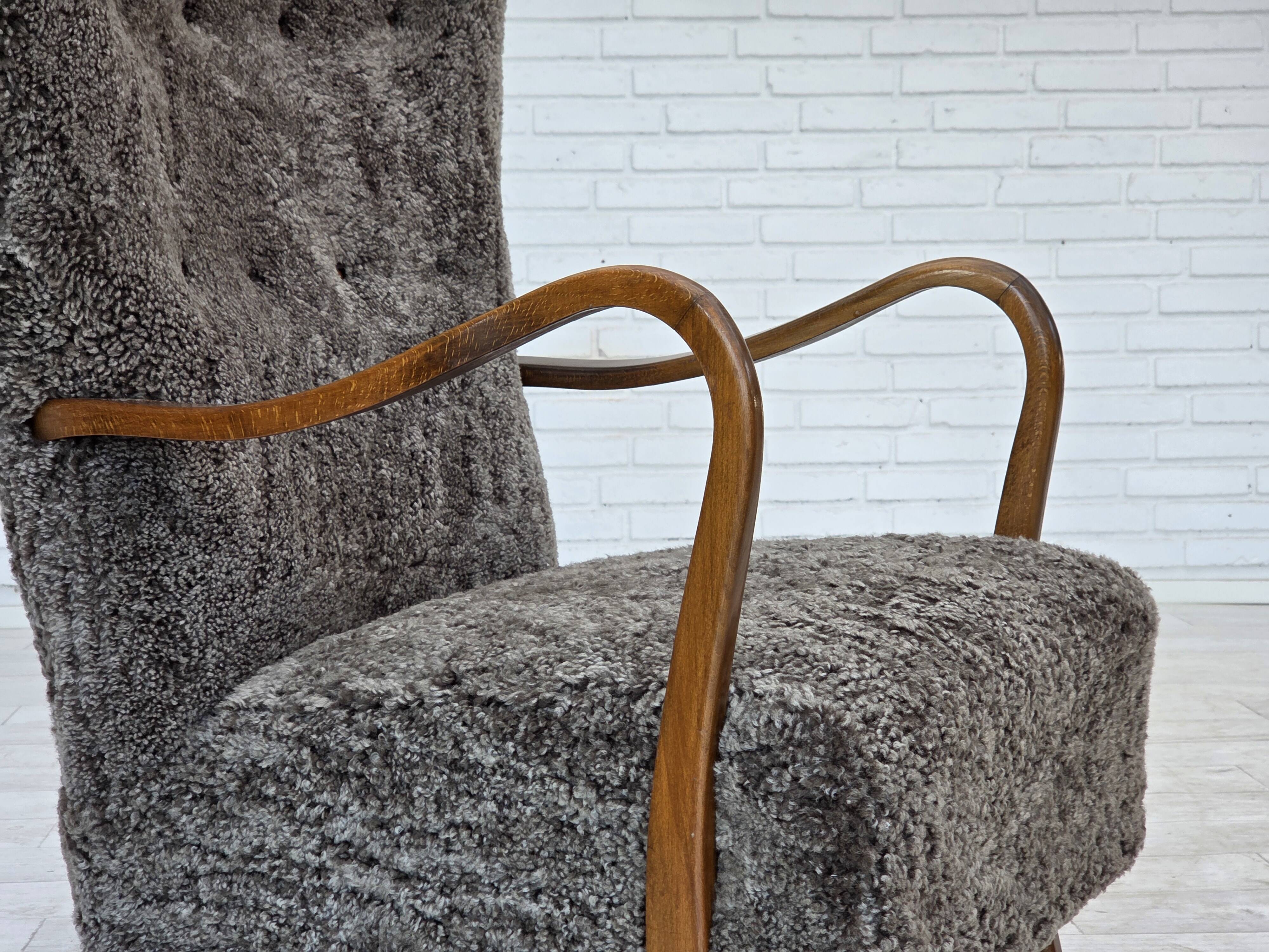 1960s, reupholstered Danish armchair, with stool, genuine sheepskin.