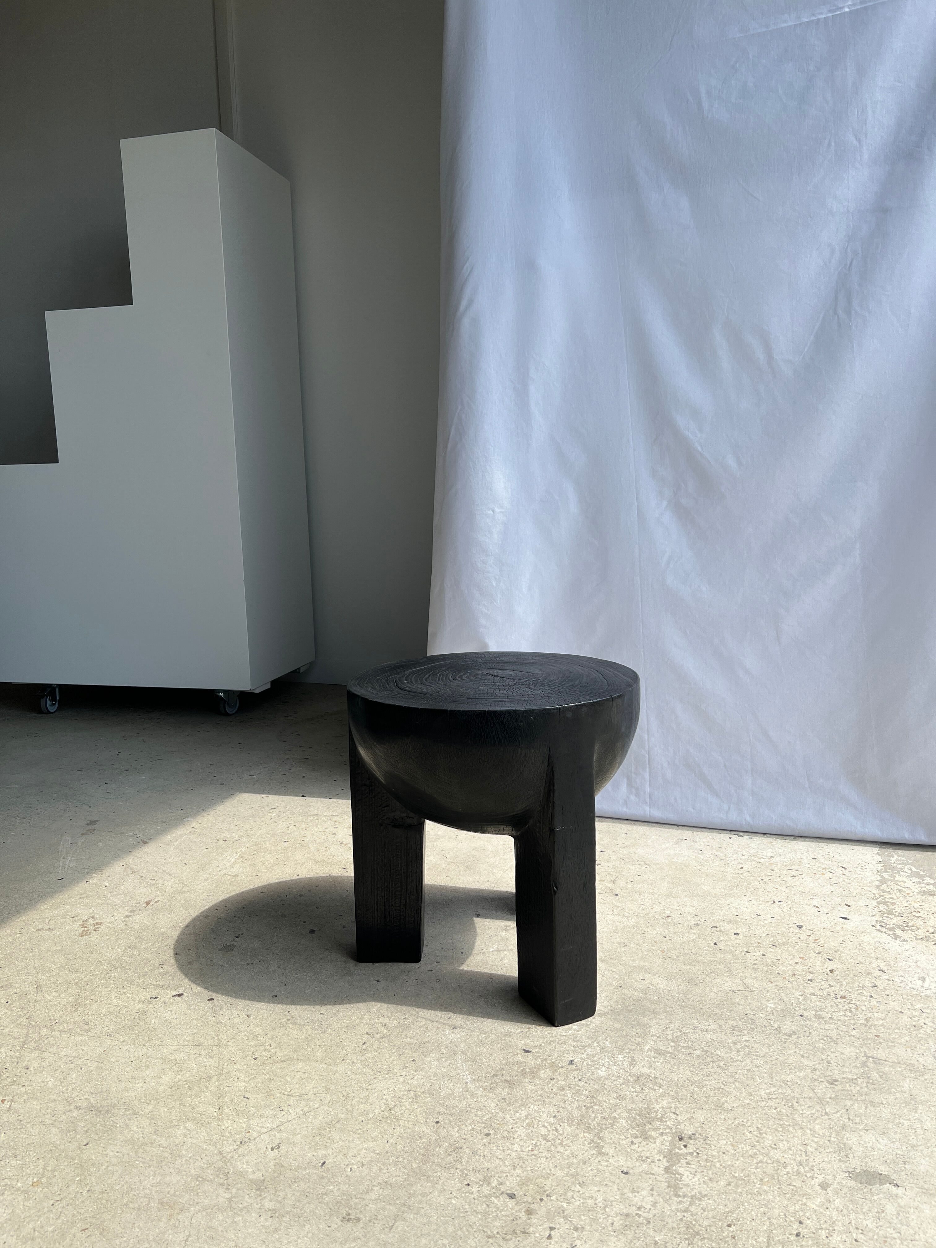 Black mango wood tripod side table with a semi-spherical top, height: 45 cm, diameter: 44 cm.
