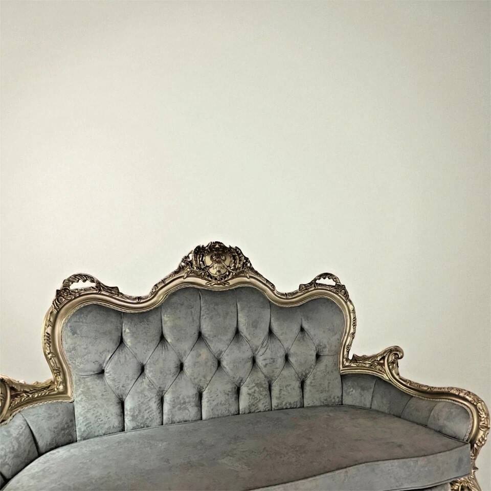 A soft light blue and silver tufted beech wood sofa in Louis style.