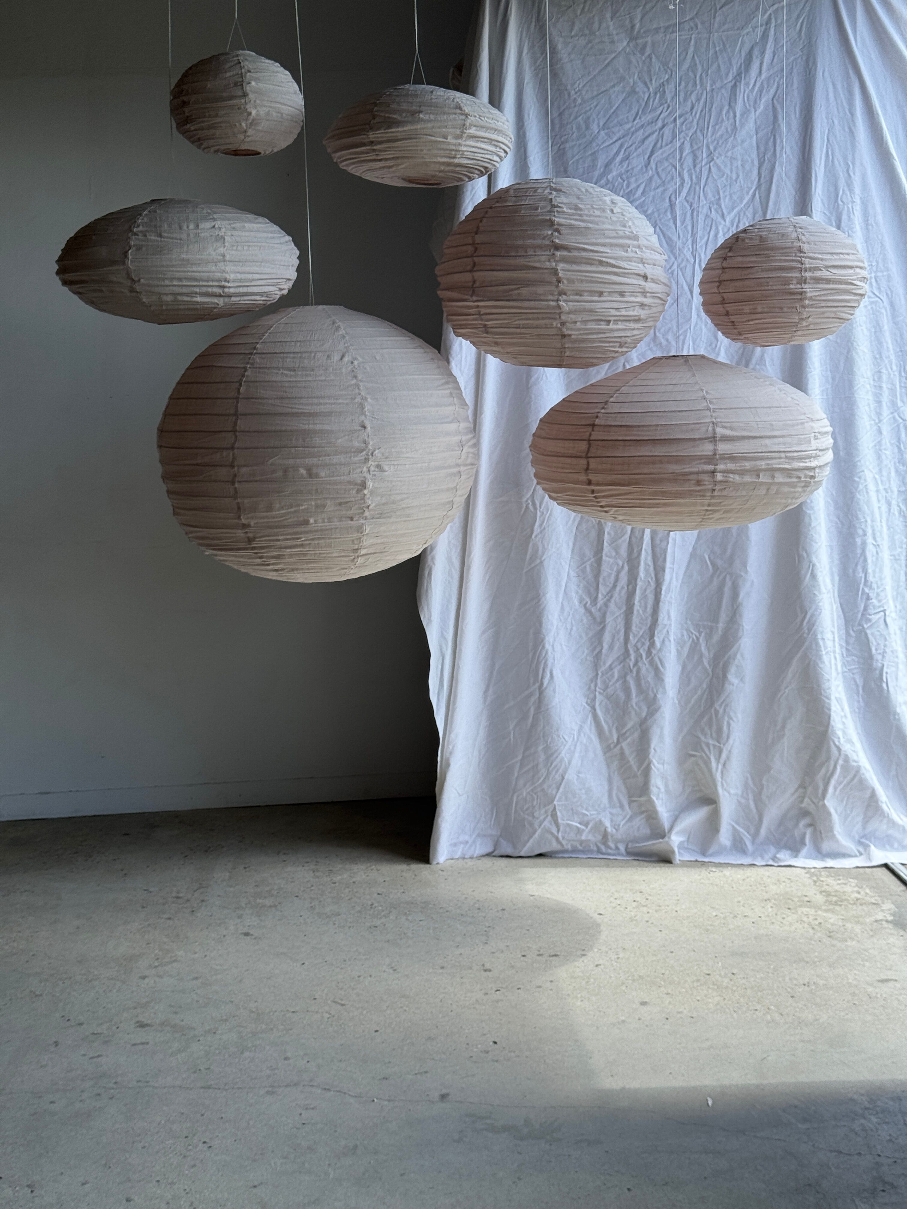Grande suspension en rotin et lin naturel japonisante ovale aplatie rosée