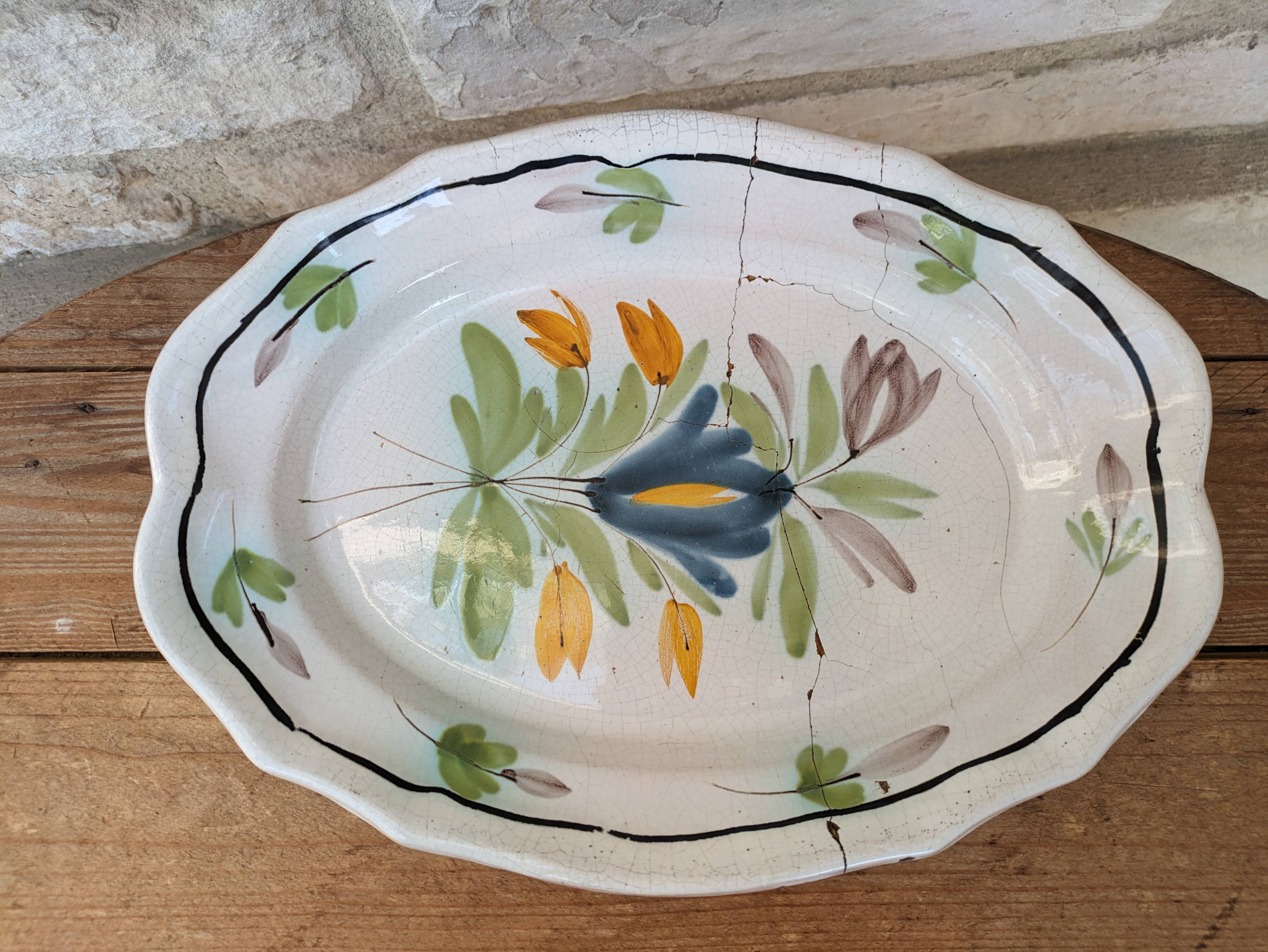 Old oval dish with floral motif called black bottom with staples
