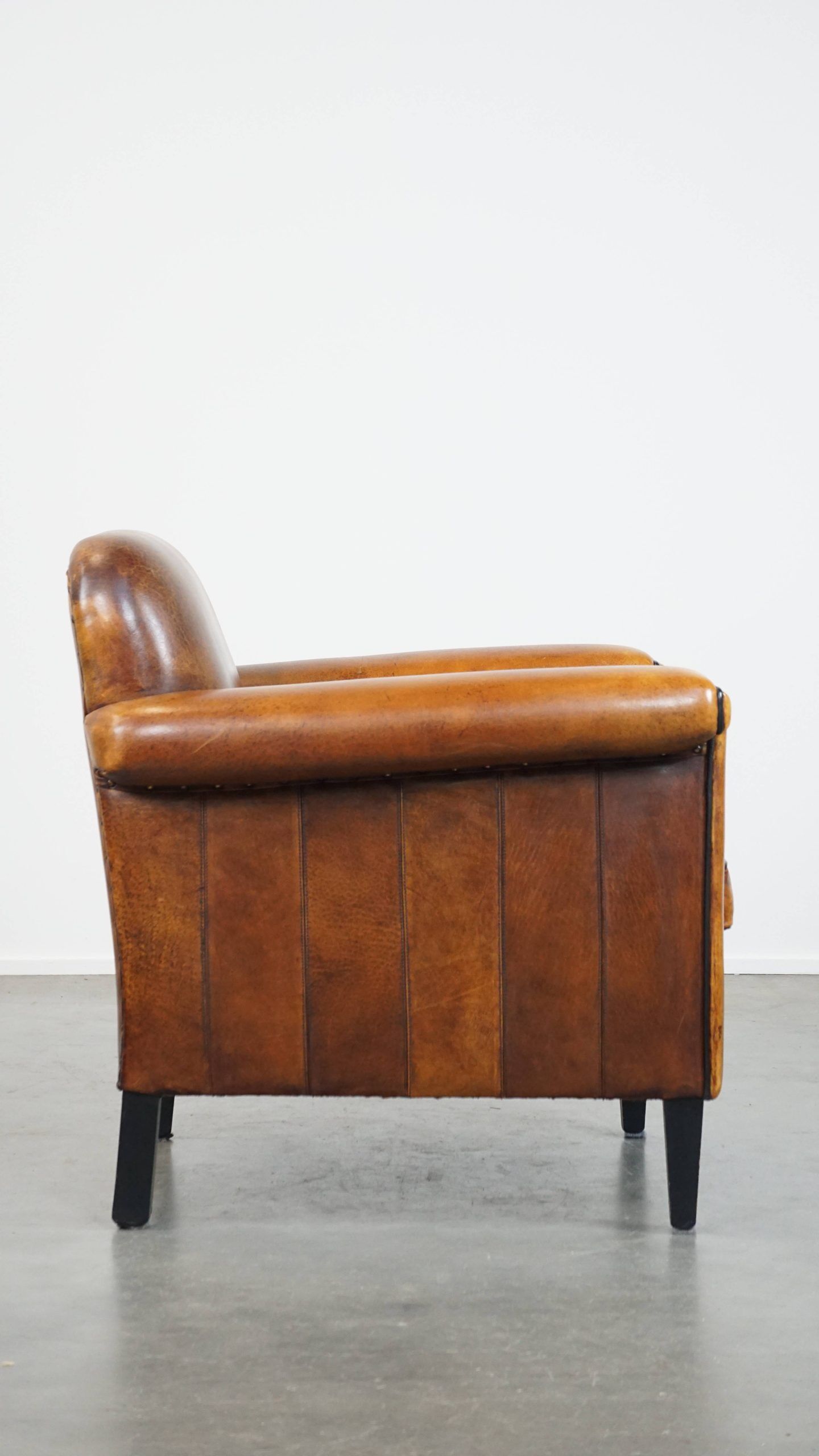 Sheepskin Art Deco design armchair with sleek finish and black piping