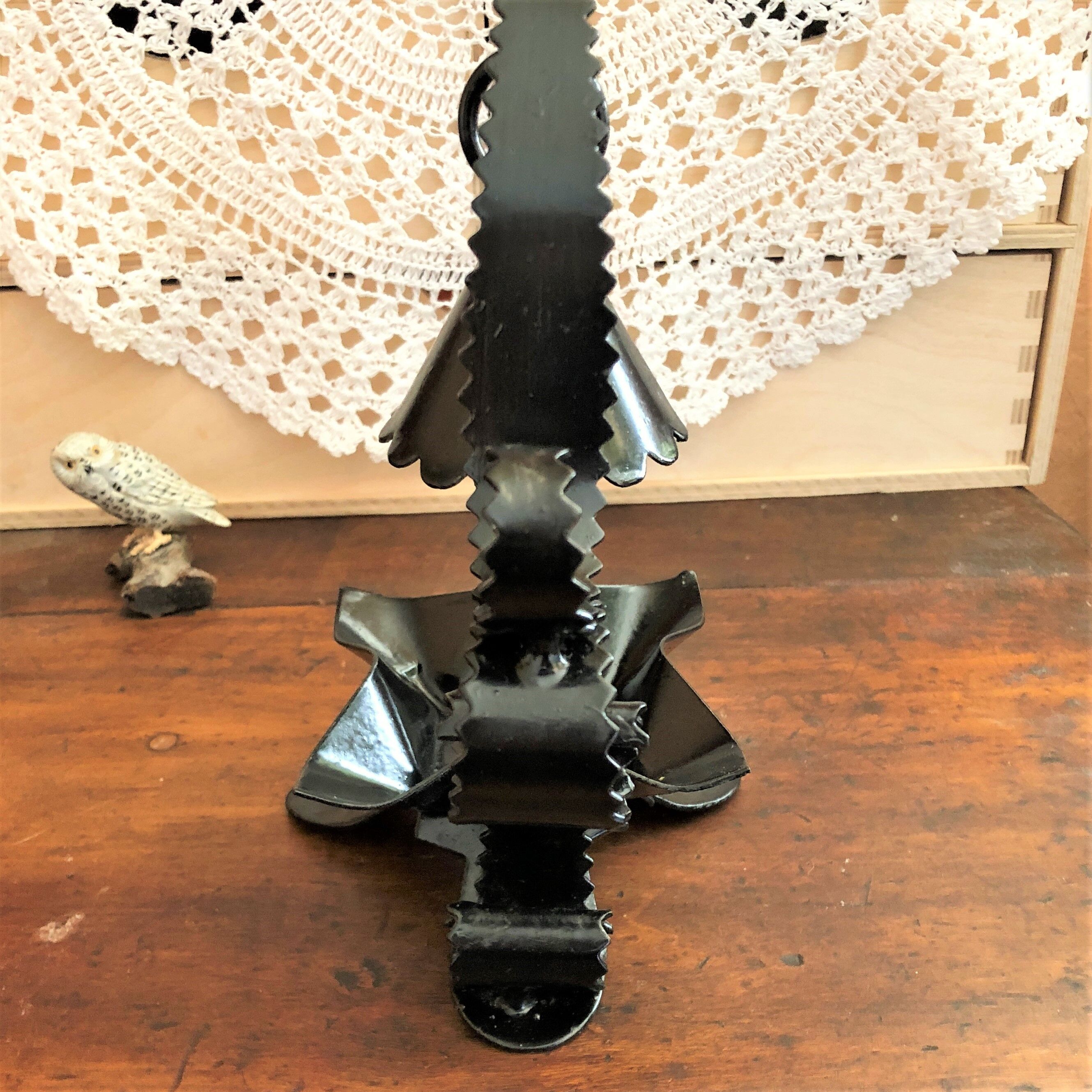 Handcrafted black wrought iron candle holder with its vintage extinguisher