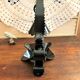 Handcrafted black wrought iron candle holder with its vintage extinguisher