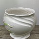 White ceramic pot cache of flower slip and old green foliage
