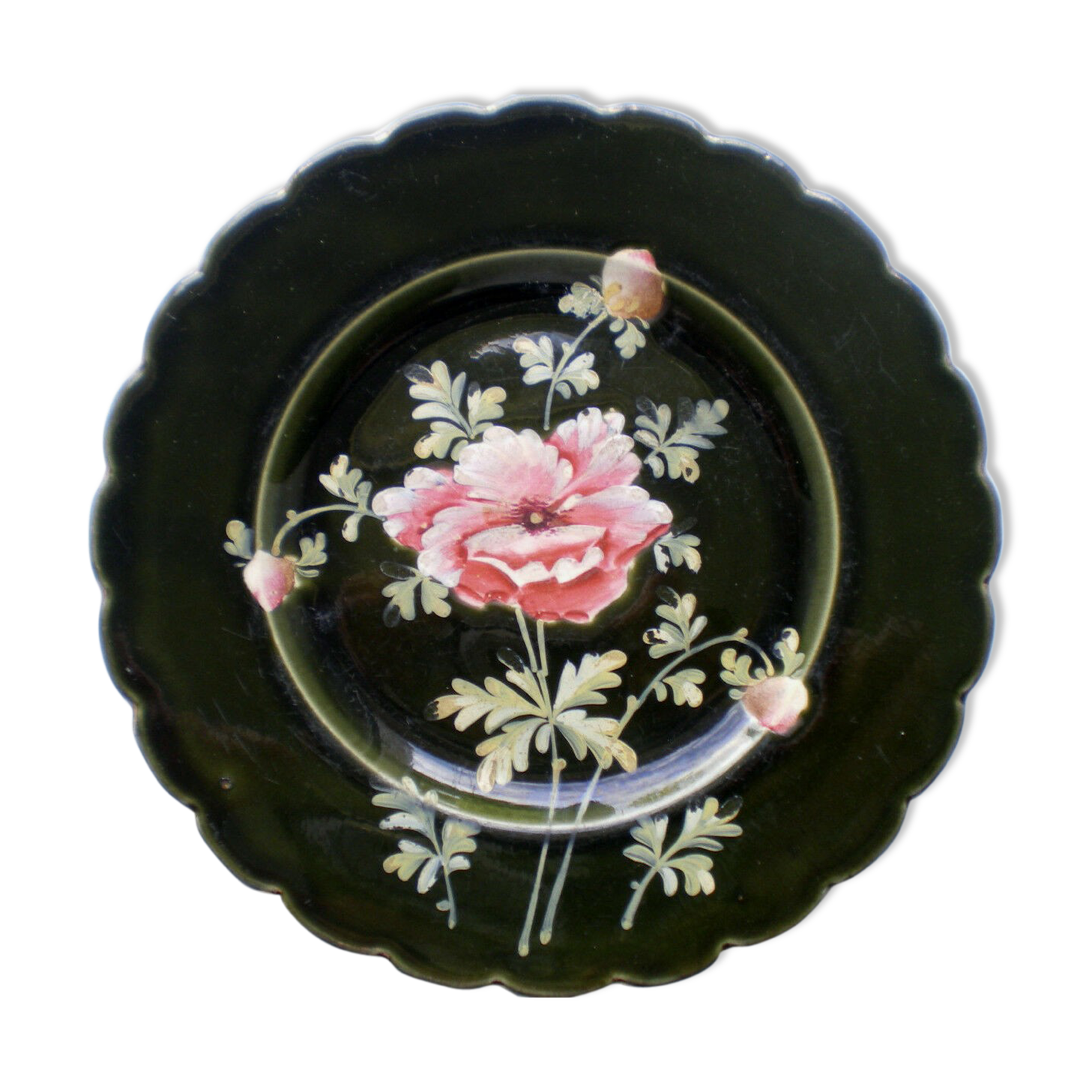Old plate decorated with anemones or poppies on a black background
