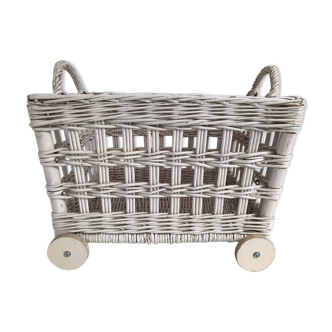 Wicker laundry basket on vintage wooden wheels