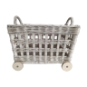 Wicker laundry basket on vintage wooden wheels