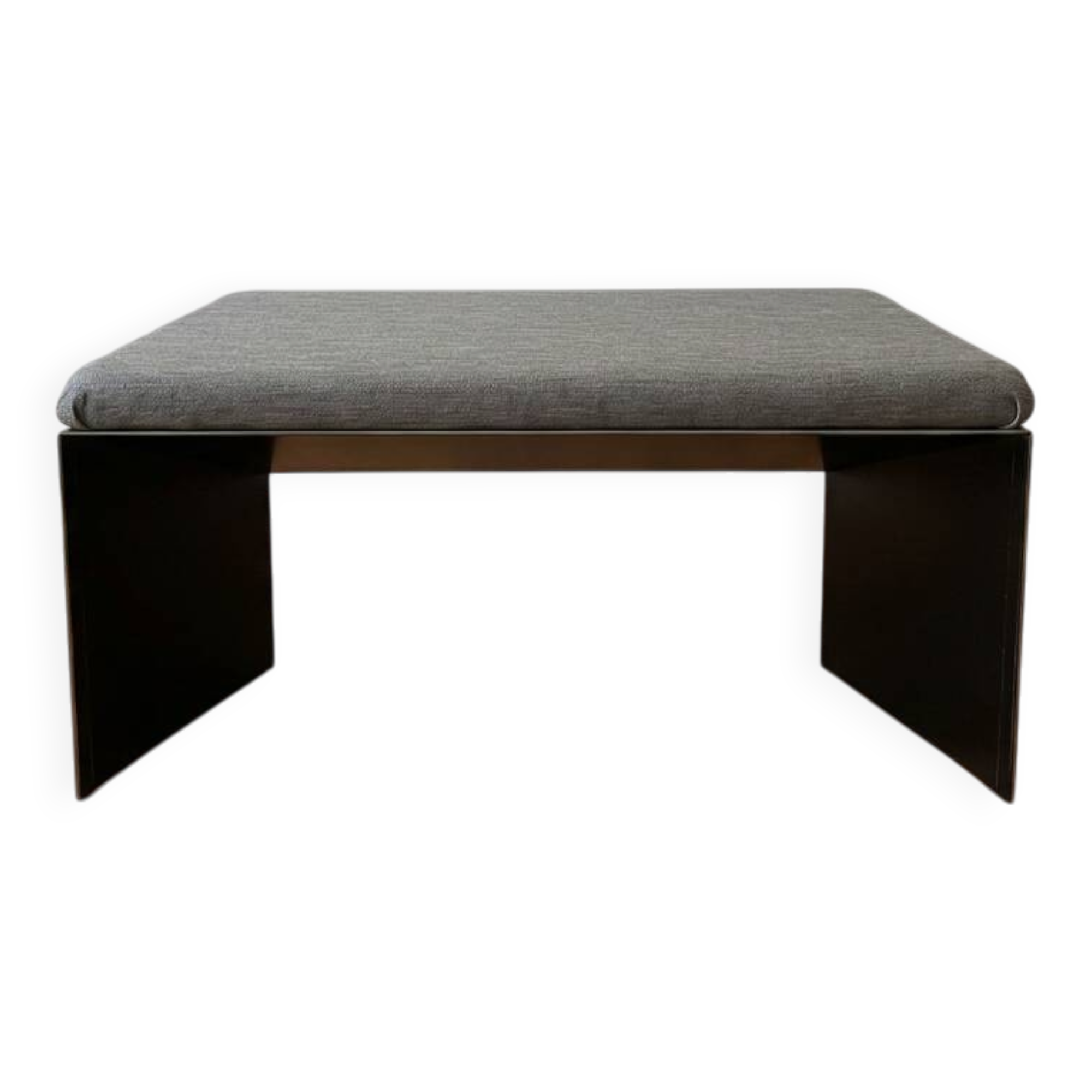Minimalist/industrial coffee table with a black metal frame and a grey fabric top.