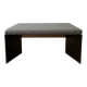 Minimalist/industrial coffee table with a black metal frame and a grey fabric top.