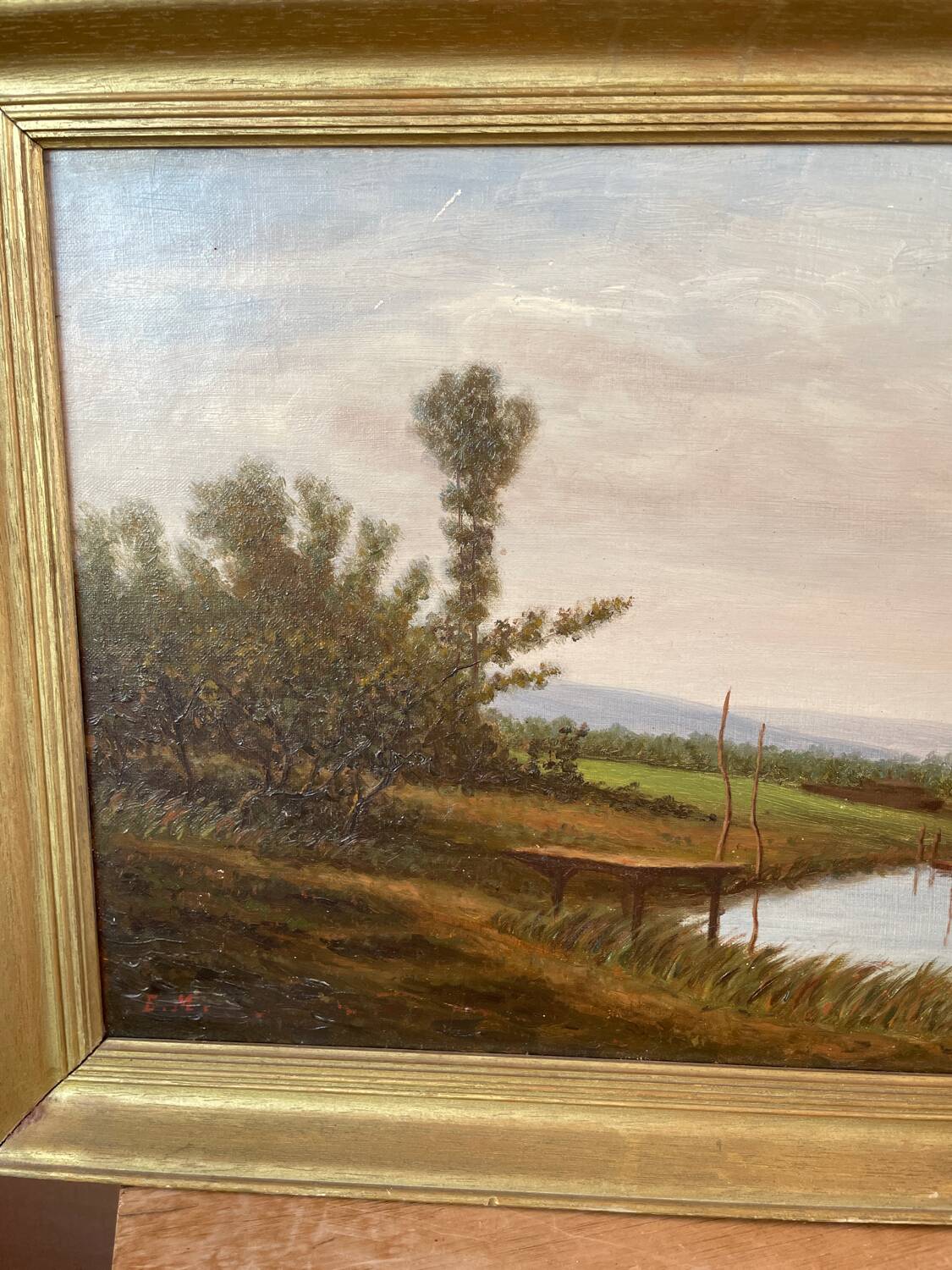 Oil painting of a riverside signed EM