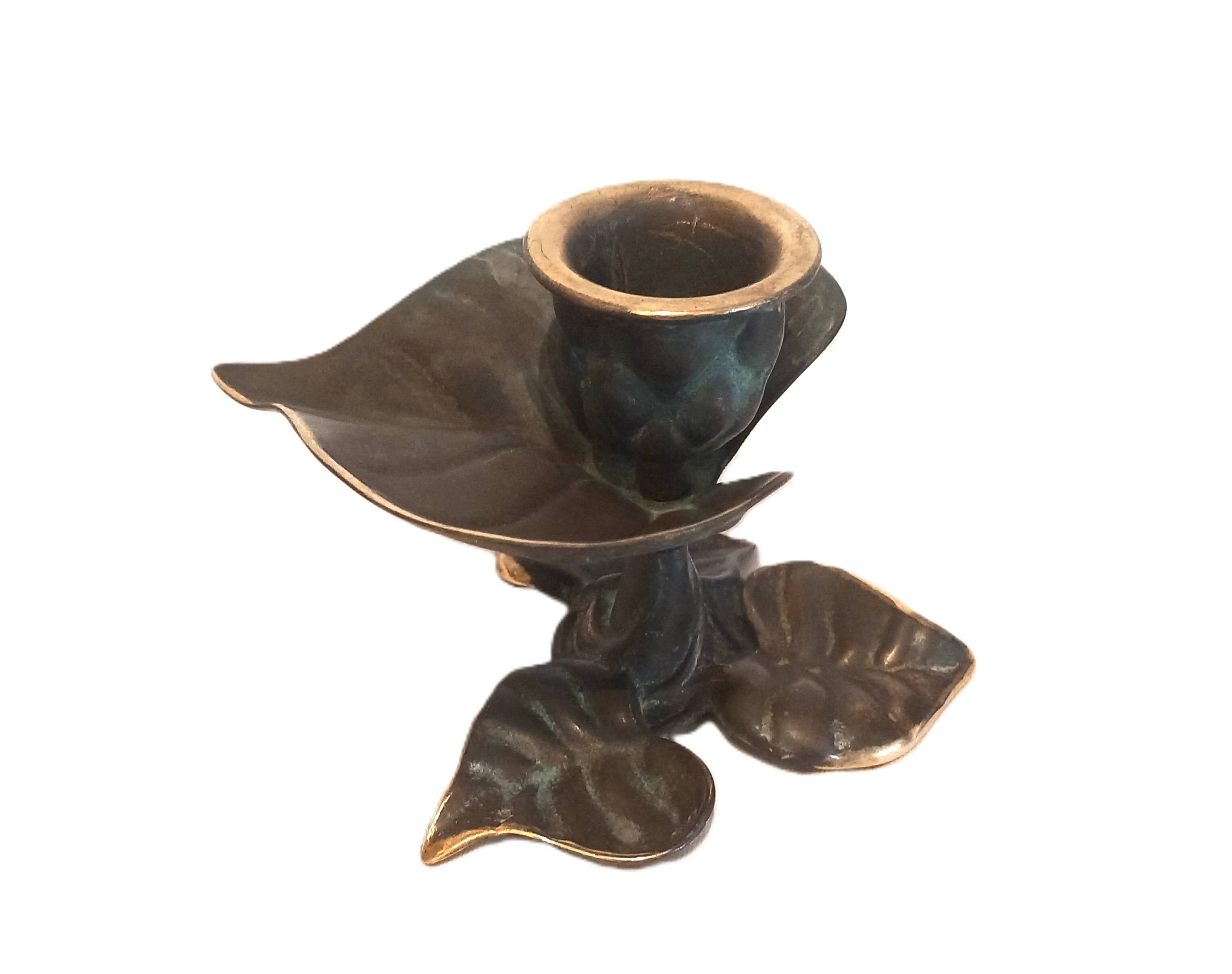 Patinated green brass candlestick with foliage decoration.
