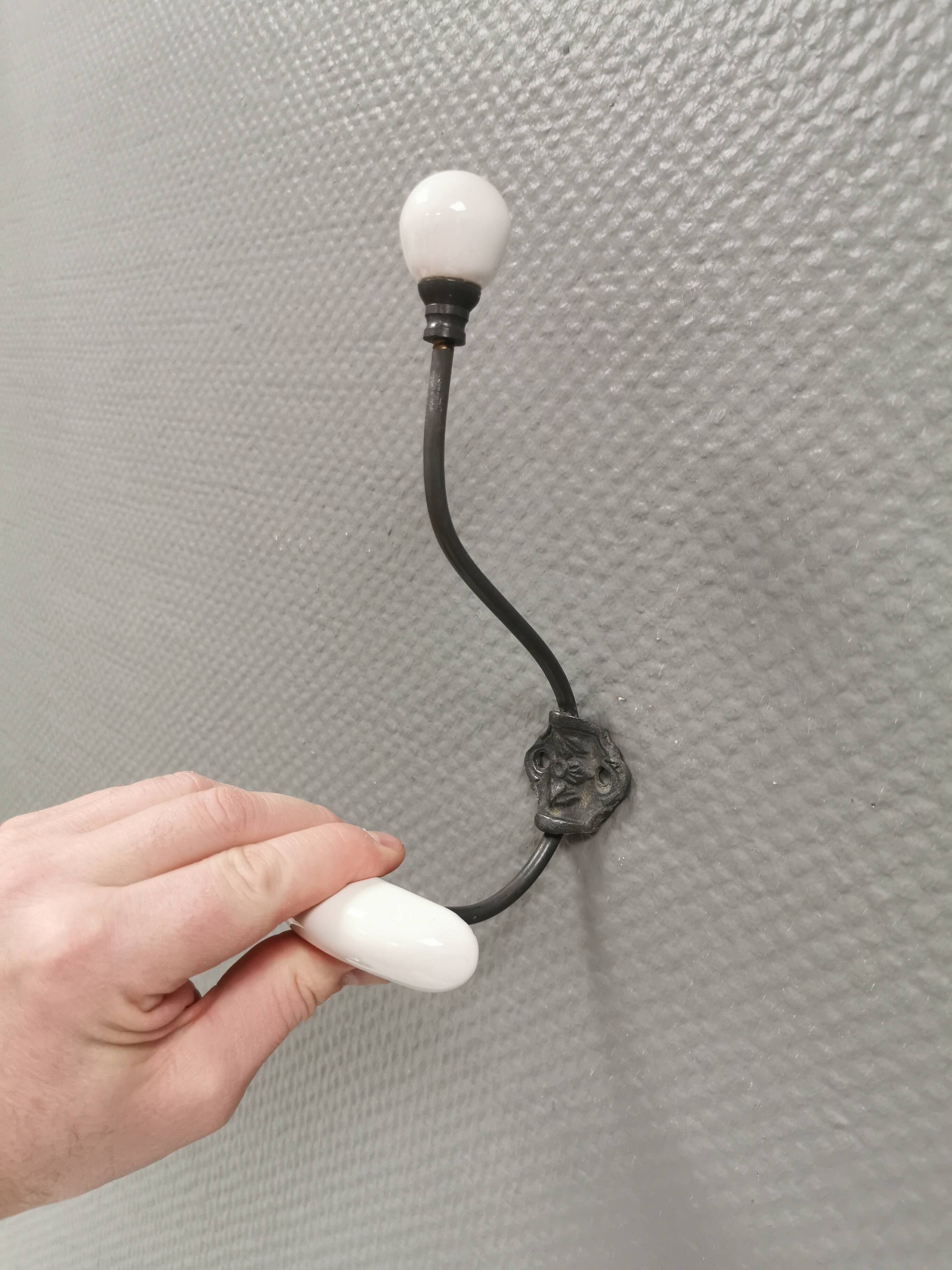 Coat hooks made of galvanized brass and raw white porcelain