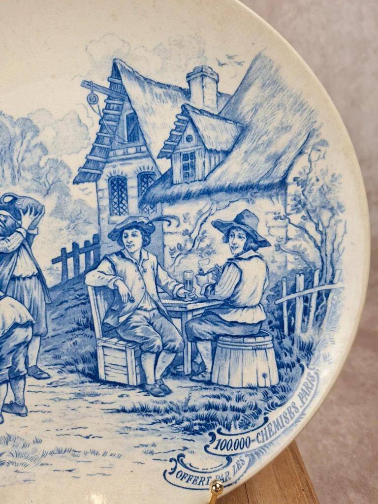 Old advertising plate with blue decoration after Teniers – 100,000 Shirts Paris