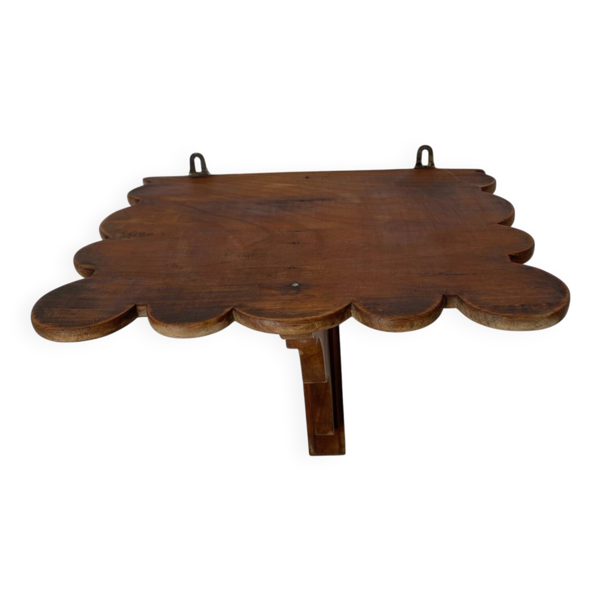 Antique wall shelf with a scalloped edge.