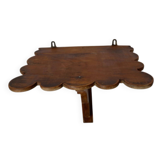 Antique wall shelf with a scalloped edge.
