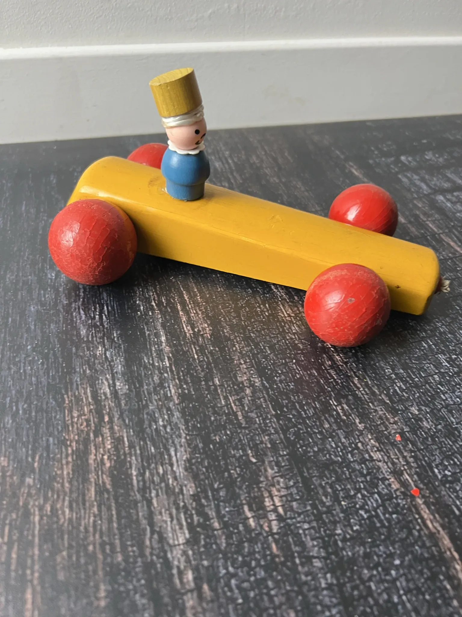 Vintage wooden pull toy, yellow car and small soldier.