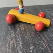 Vintage wooden pull toy, yellow car and small soldier.