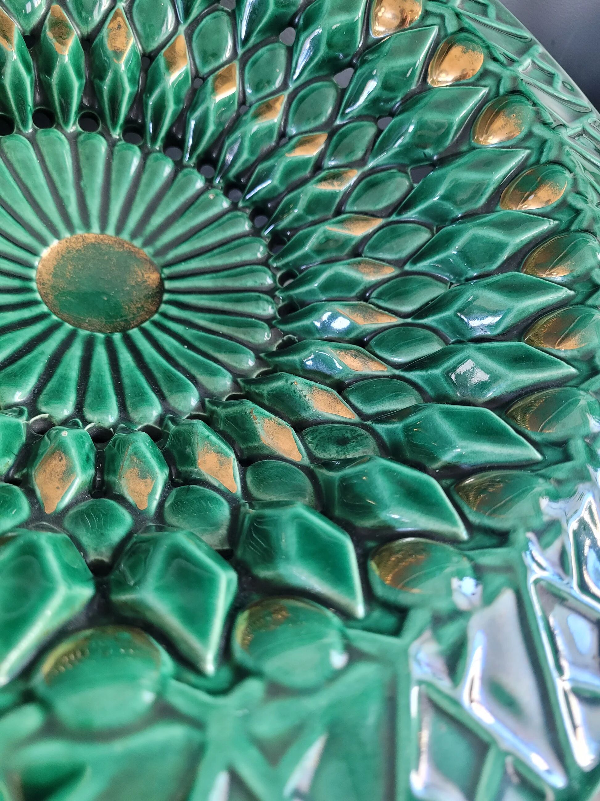 Large pierced earthenware fruit bowl glazed in green and gold.